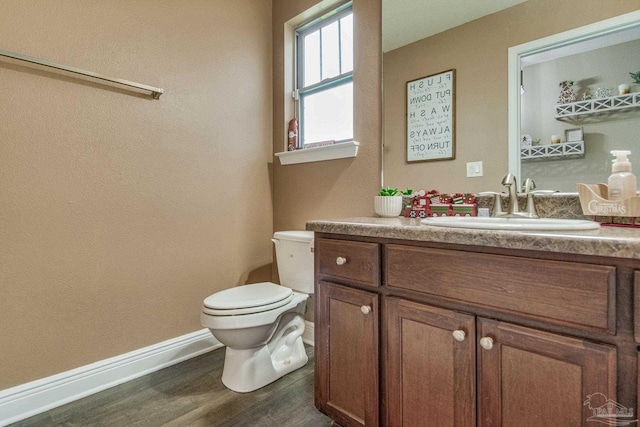 bathroom with hardwood / wood-style floors, vanity, and toilet