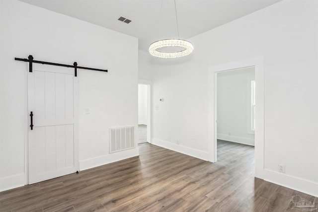 interior space with a barn door and wood-type flooring