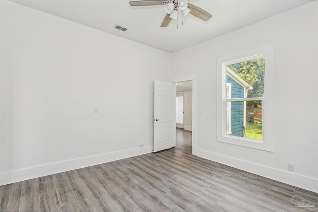 spare room with light hardwood / wood-style flooring, ceiling fan, and a wealth of natural light