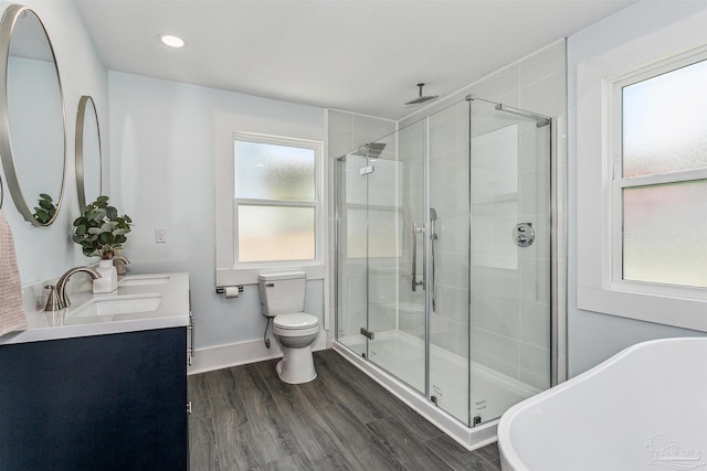 full bathroom with a wealth of natural light, vanity, toilet, and hardwood / wood-style floors