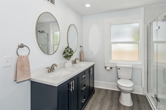 bathroom with vanity, a shower with shower door, toilet, and hardwood / wood-style flooring