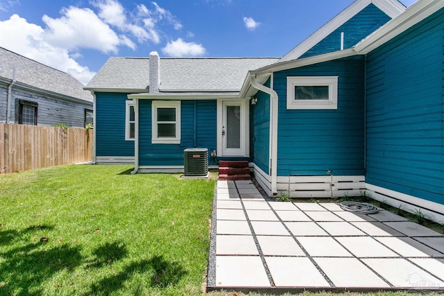 doorway to property featuring central air condition unit, a yard, and a patio