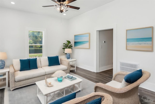 living room featuring ceiling fan and dark hardwood / wood-style flooring