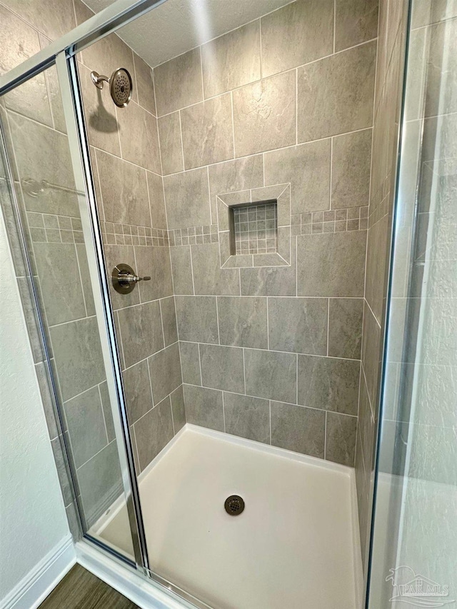 full bathroom featuring baseboards and a stall shower