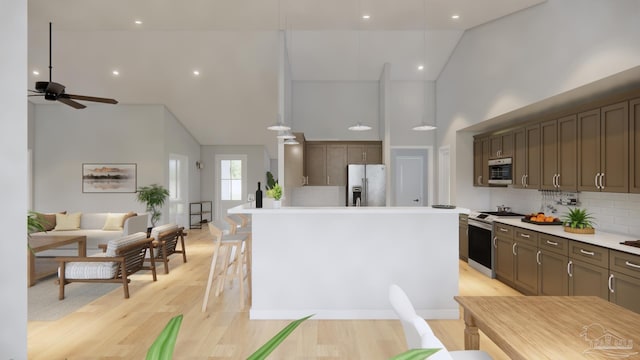 kitchen featuring decorative backsplash, light hardwood / wood-style flooring, a center island, appliances with stainless steel finishes, and high vaulted ceiling