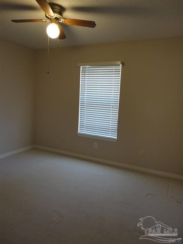 carpeted spare room featuring ceiling fan and a textured ceiling