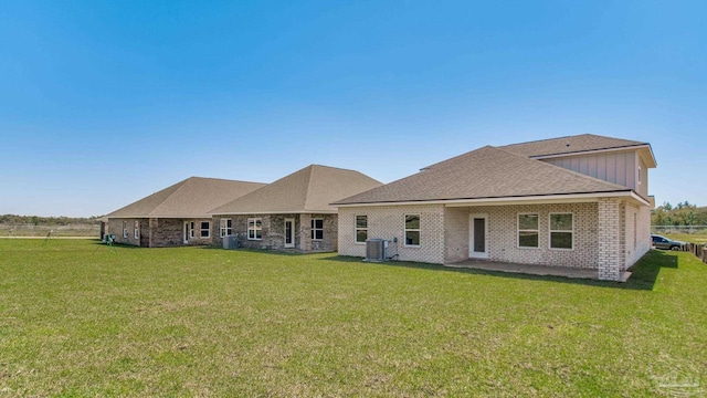 2733 Chevy Cir, Pace, FL 32571 - rear view of property featuring central air condition unit, a lawn, a shingled roof, brick siding, and board and batten siding