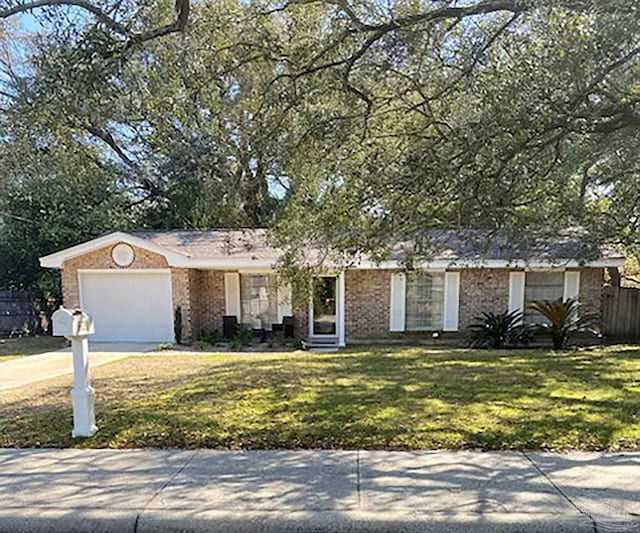 ranch-style home featuring a front lawn, an attached garage, fence, and driveway