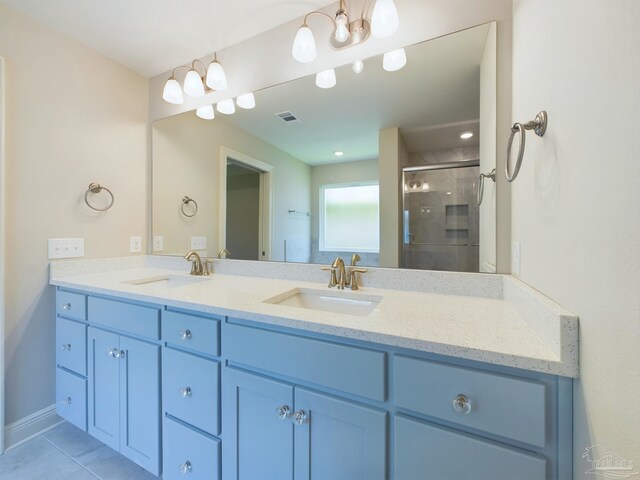 bathroom with tile patterned flooring, a shower with shower door, and dual bowl vanity