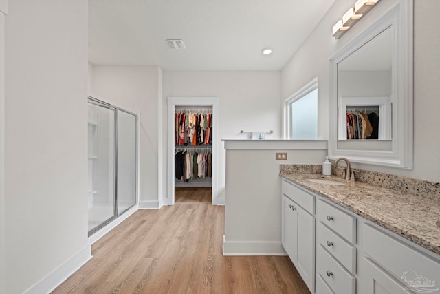 3416 Southwind Dr, Gulf Breeze, FL 32563 - full bathroom with a walk in closet, vanity, a stall shower, wood finished floors, and baseboards