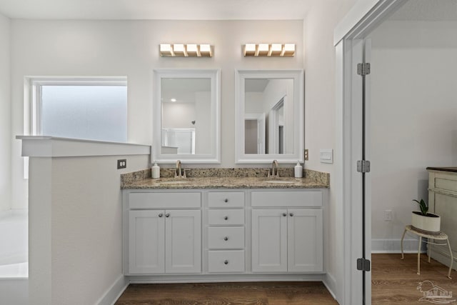 3416 Southwind Dr, Gulf Breeze, FL 32563 - bathroom featuring double vanity, wood finished floors, a tub, and baseboards