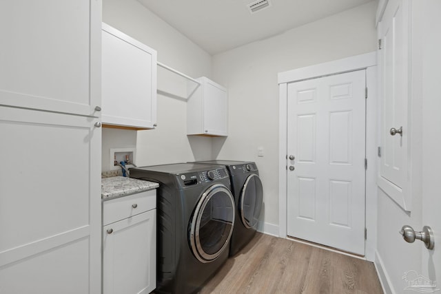 3416 Southwind Dr, Gulf Breeze, FL 32563 - laundry room with cabinet space, light wood finished floors, washer and clothes dryer, and baseboards