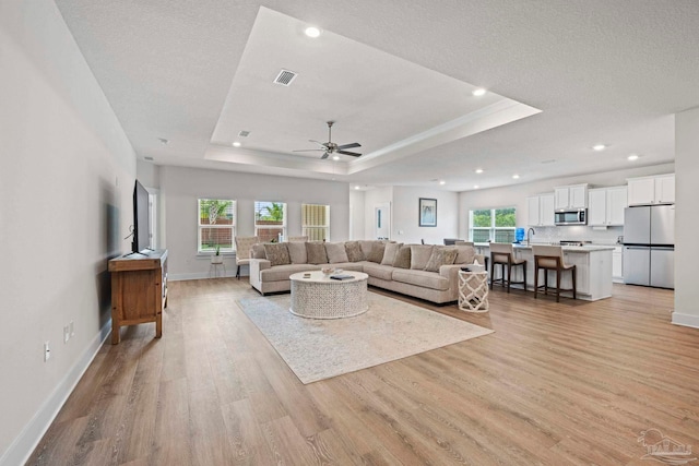 3416 Southwind Dr, Gulf Breeze, FL 32563 - living room with a tray ceiling, light wood-style flooring, ceiling fan, baseboards, and recessed lighting
