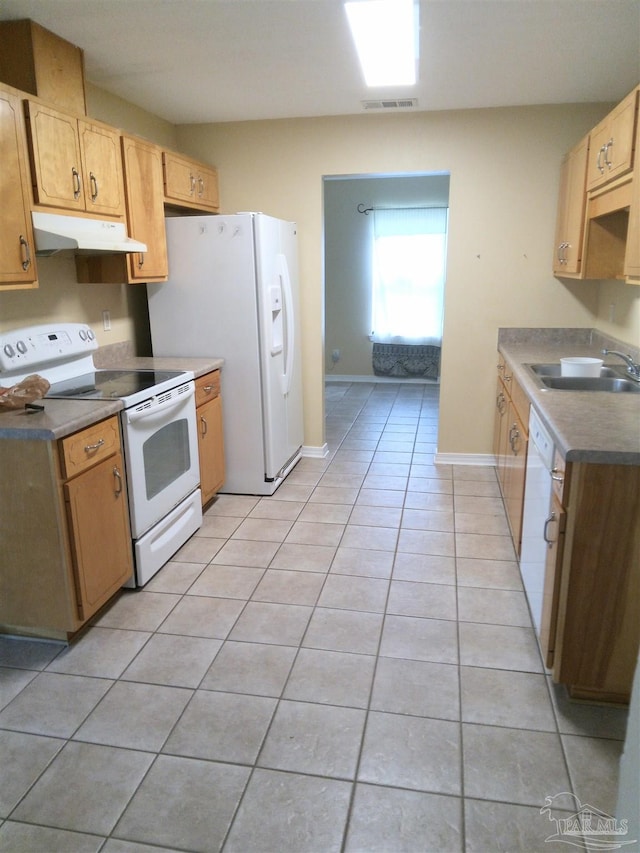 kitchen featuring white appliances, light tile patterned flooring, and sink