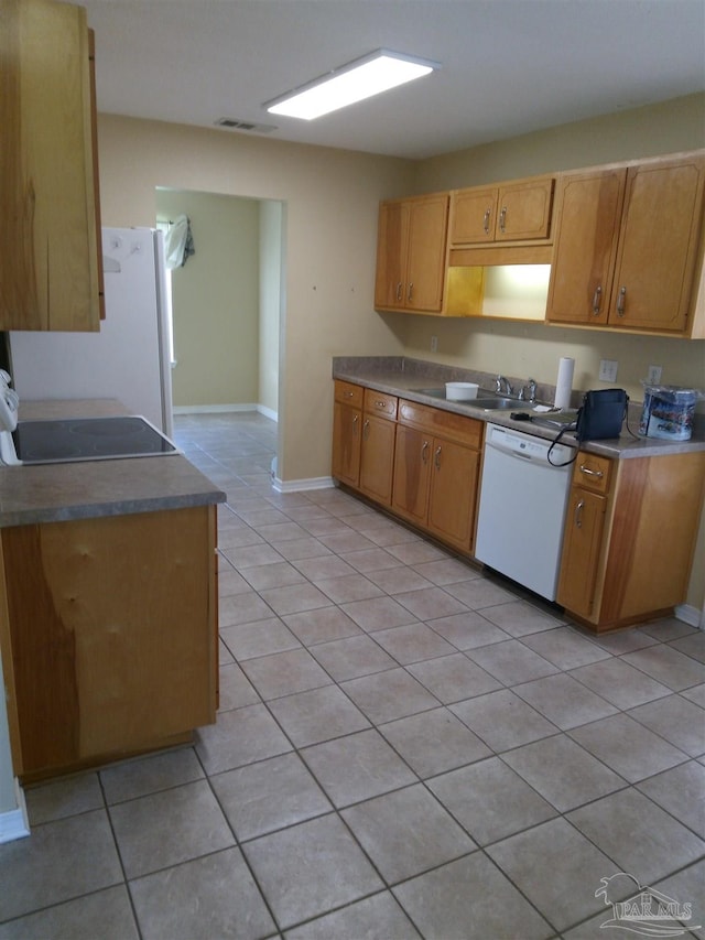 kitchen with white appliances, sink, and light tile patterned floors