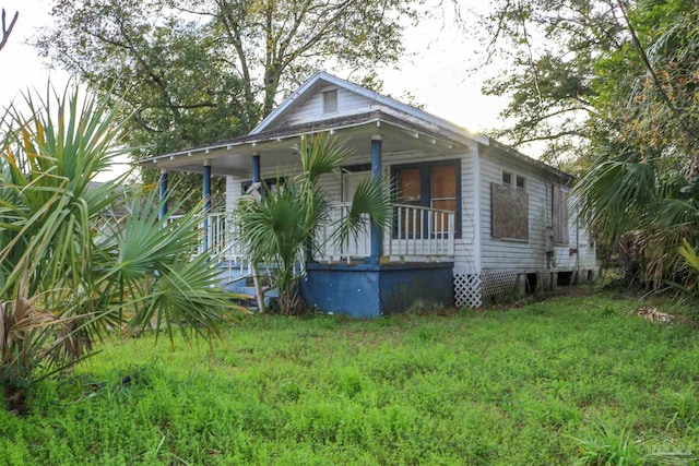 bungalow with a front yard and covered porch