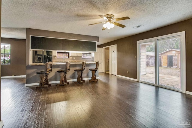 interior space with dark hardwood / wood-style floors, a textured ceiling, and ceiling fan