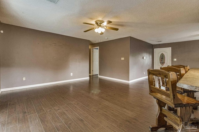 interior space with ceiling fan, a textured ceiling, and dark hardwood / wood-style flooring