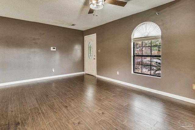 unfurnished room featuring dark wood-type flooring and ceiling fan