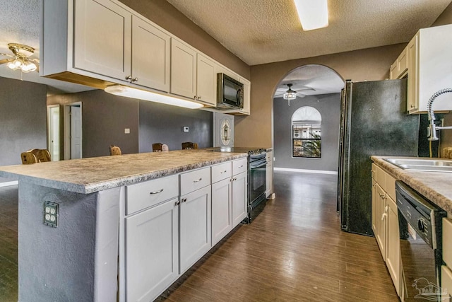 kitchen with white cabinetry, ceiling fan, dark hardwood / wood-style flooring, and black appliances