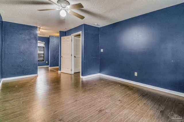 empty room with ceiling fan, hardwood / wood-style floors, and a textured ceiling