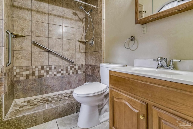 bathroom with vanity, tile patterned floors, toilet, and tiled shower