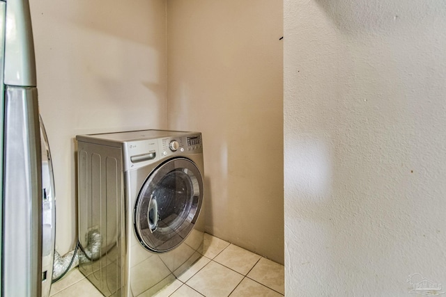 laundry area featuring light tile patterned floors and washer / dryer