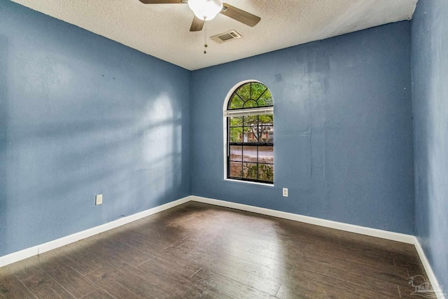 spare room featuring dark hardwood / wood-style floors, a textured ceiling, and ceiling fan