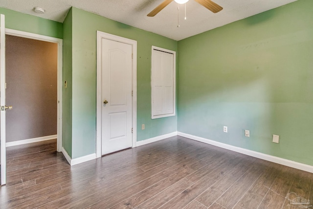 unfurnished bedroom featuring dark hardwood / wood-style floors, a textured ceiling, and ceiling fan