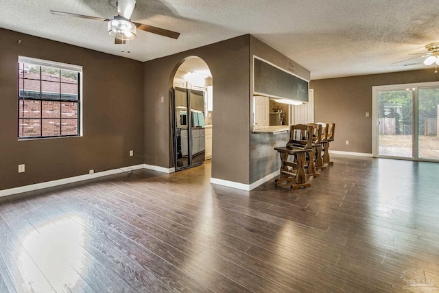 interior space featuring dark wood-type flooring, a textured ceiling, and ceiling fan