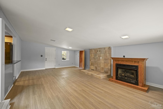 204 Camelia St, Gulf Breeze, FL 32561 - unfurnished living room featuring a fireplace with raised hearth, wood finished floors, lofted ceiling, and baseboards