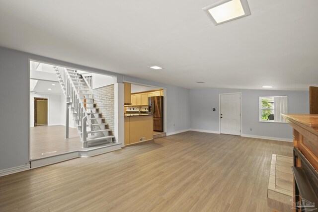 204 Camelia St, Gulf Breeze, FL 32561 - unfurnished living room with light wood finished floors, stairway, and baseboards