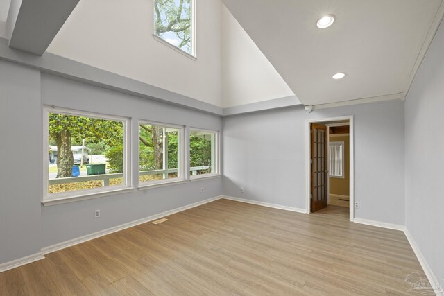 204 Camelia St, Gulf Breeze, FL 32561 - unfurnished room with plenty of natural light, baseboards, light wood-style floors, recessed lighting, and a high ceiling