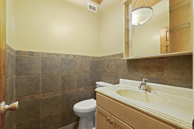 204 Camelia St, Gulf Breeze, FL 32561 - bathroom featuring tile walls, toilet, vanity, and wainscoting