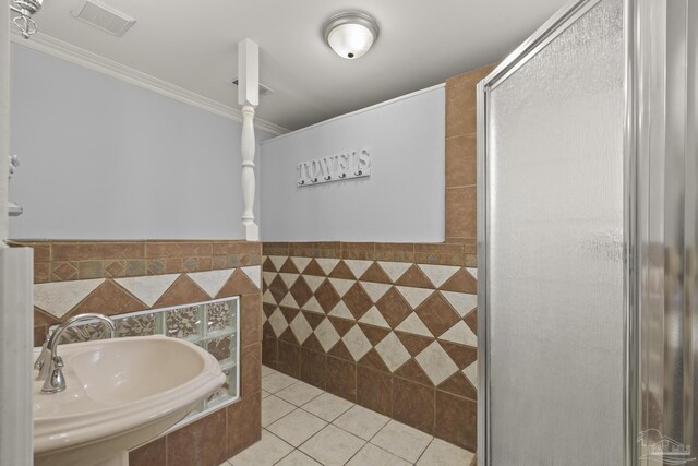 204 Camelia St, Gulf Breeze, FL 32561 - bathroom with a sink, crown molding, tile patterned floors, a shower, and tile walls