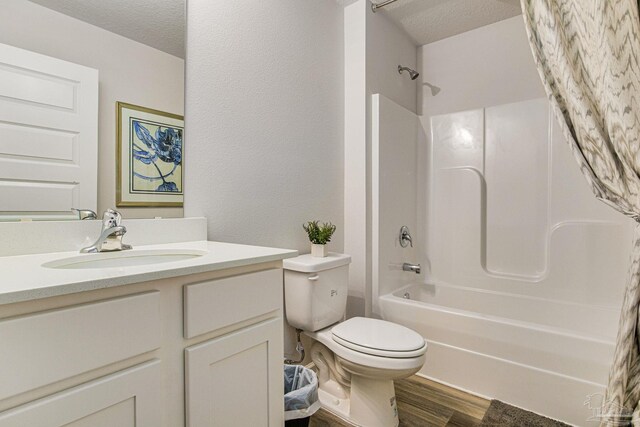 full bathroom with shower / bath combination with curtain, a textured ceiling, toilet, vanity, and hardwood / wood-style floors