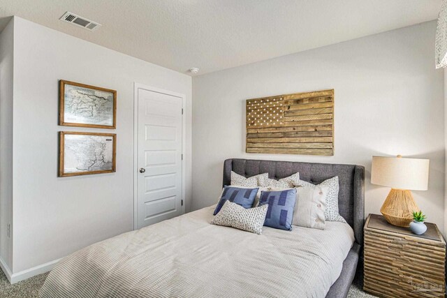 carpeted bedroom featuring a textured ceiling