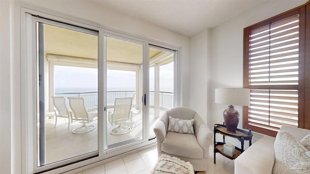 living area featuring light tile patterned flooring and a water view