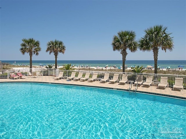 view of pool with a water view and a patio area