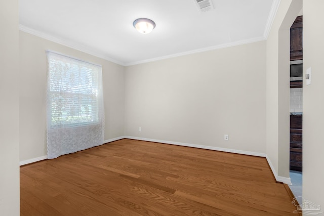 unfurnished room with wood-type flooring and crown molding