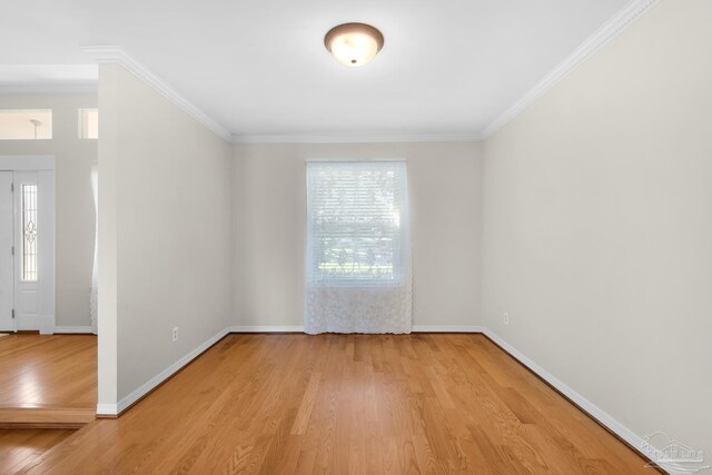 empty room featuring light wood-type flooring and ornamental molding