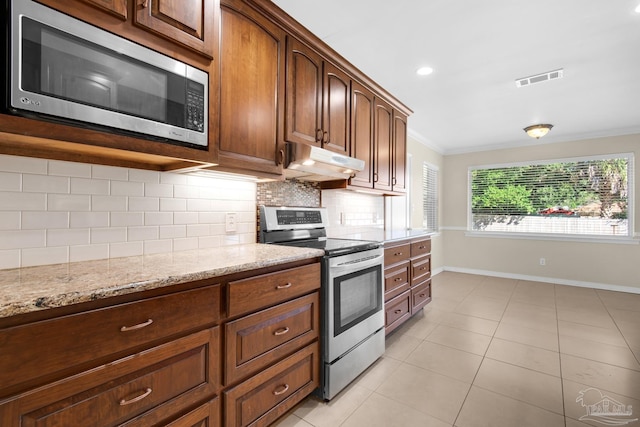 kitchen featuring light stone counters, backsplash, appliances with stainless steel finishes, light tile patterned flooring, and ornamental molding