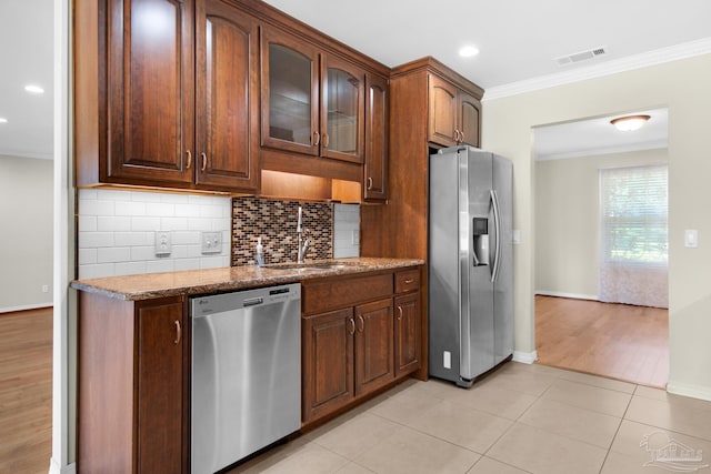 kitchen featuring light stone countertops, ornamental molding, stainless steel appliances, sink, and light hardwood / wood-style floors