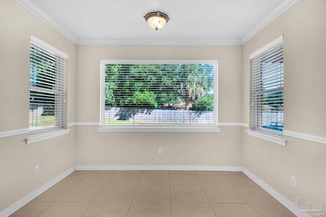 spare room featuring plenty of natural light, ornamental molding, and light tile patterned floors