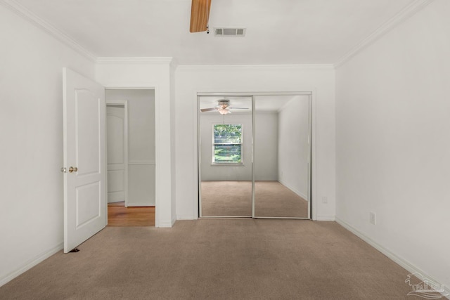 unfurnished bedroom featuring carpet, a closet, and crown molding