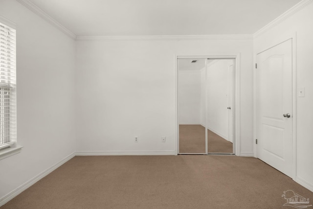 unfurnished bedroom with crown molding, a closet, and carpet floors