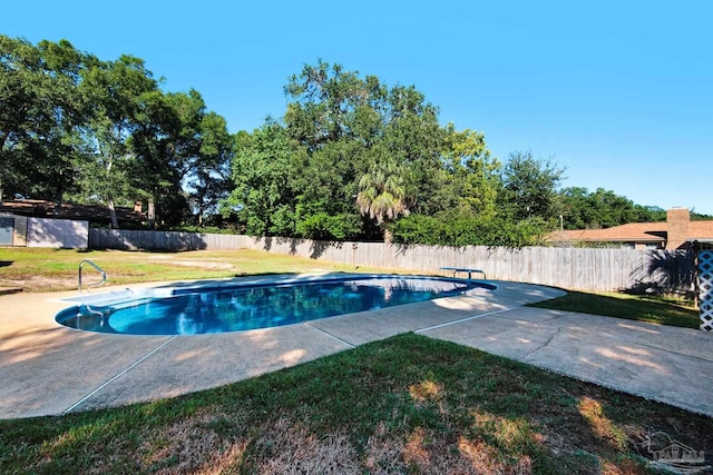 view of swimming pool with a lawn, a diving board, and a patio