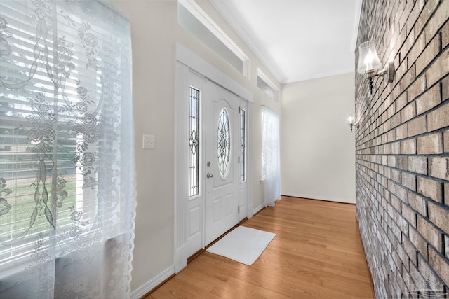 entryway featuring hardwood / wood-style floors, crown molding, and brick wall