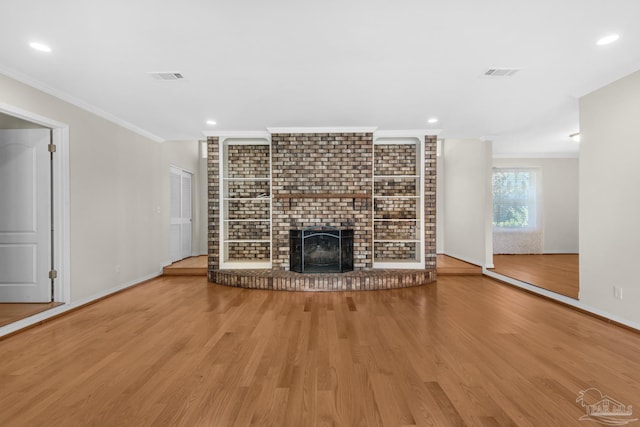 unfurnished living room featuring a fireplace, wood-type flooring, and crown molding