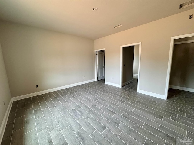 unfurnished bedroom with dark wood-style flooring and baseboards